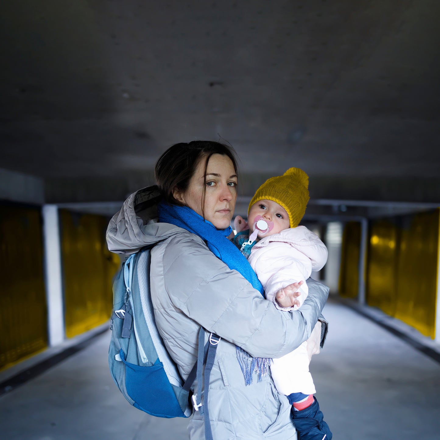 Woman holding a baby in an underground parking area