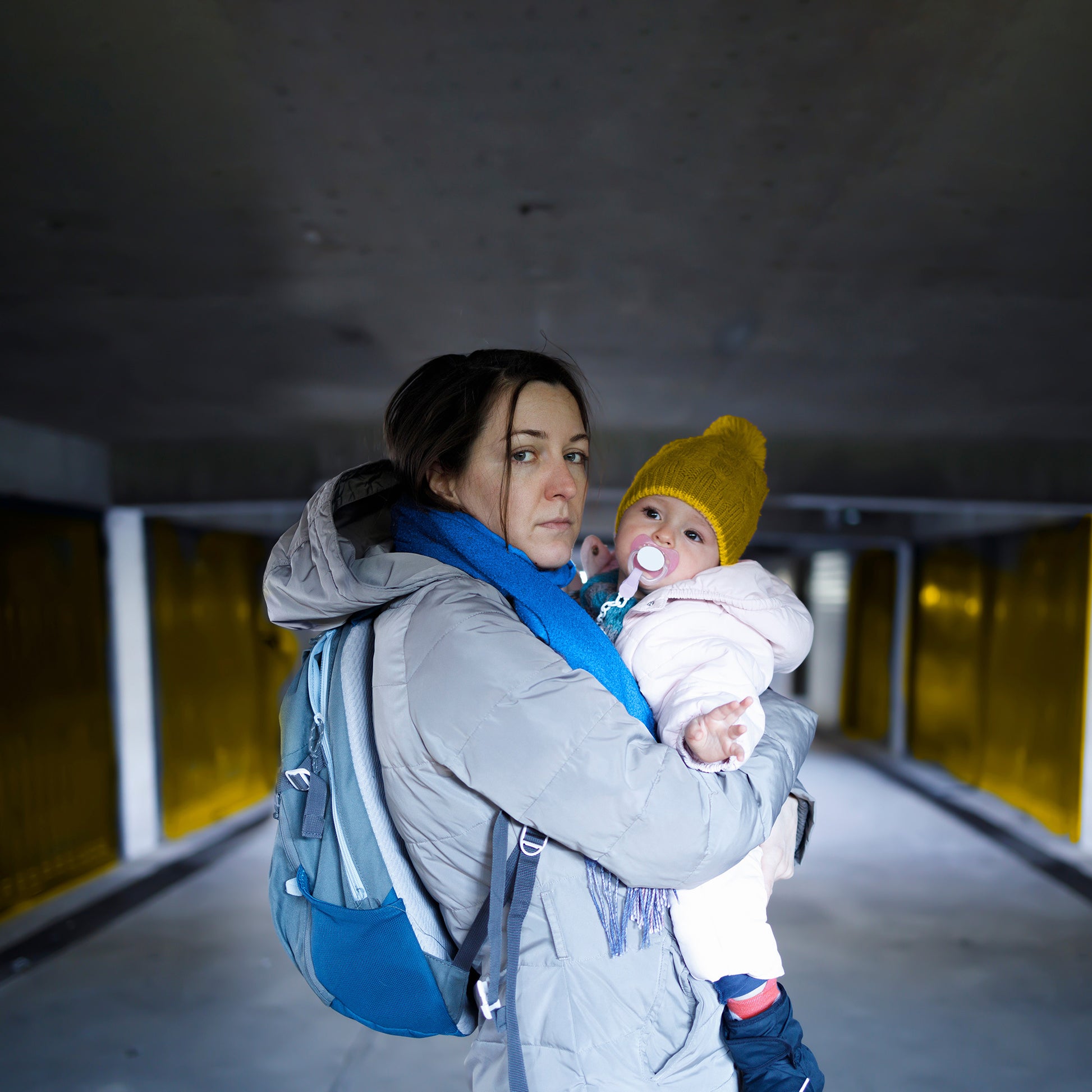Woman holding a baby in an underground parking area