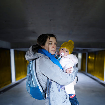 Woman holding a baby in an underground parking area