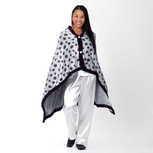 Person wearing a paw print patterned wearable blanket with two front buttons, on a white background.
