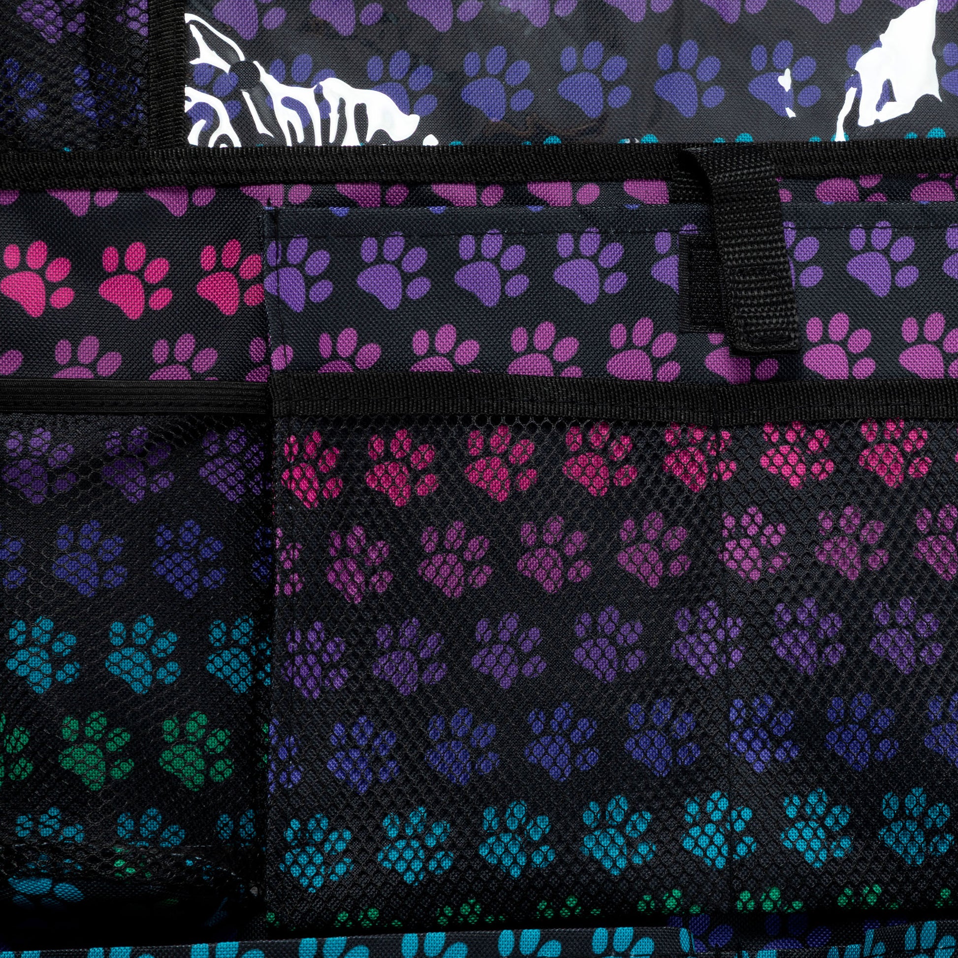Close-up of a bag with paw print pattern in black, purple, pink, and blue.