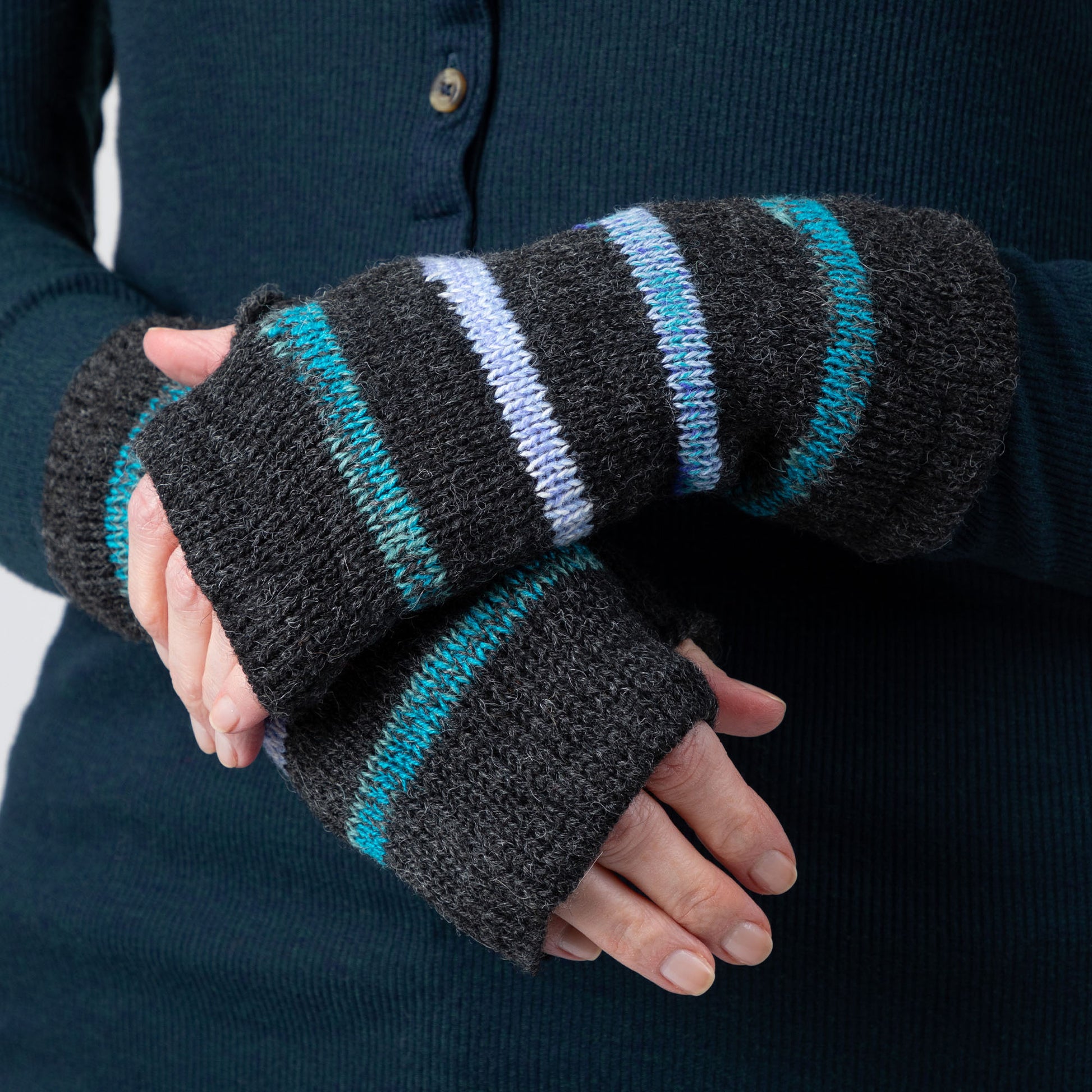 Black fingerless gloves with blue stripes worn by a person against a dark background