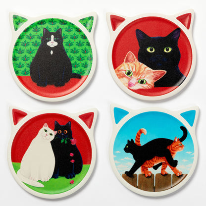 Four round cat-ear coasters arranged in a 2x2 grid on a white background. Each coaster features a different cat illustration: a black cat on green, a black cat and orange kitten on red, a white cat and black cat on red, and a black cat and orange tabby on blue.