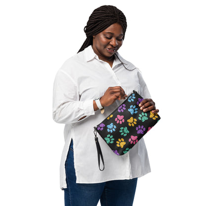 Woman holding a black clutch with paw print pattern on a white background
