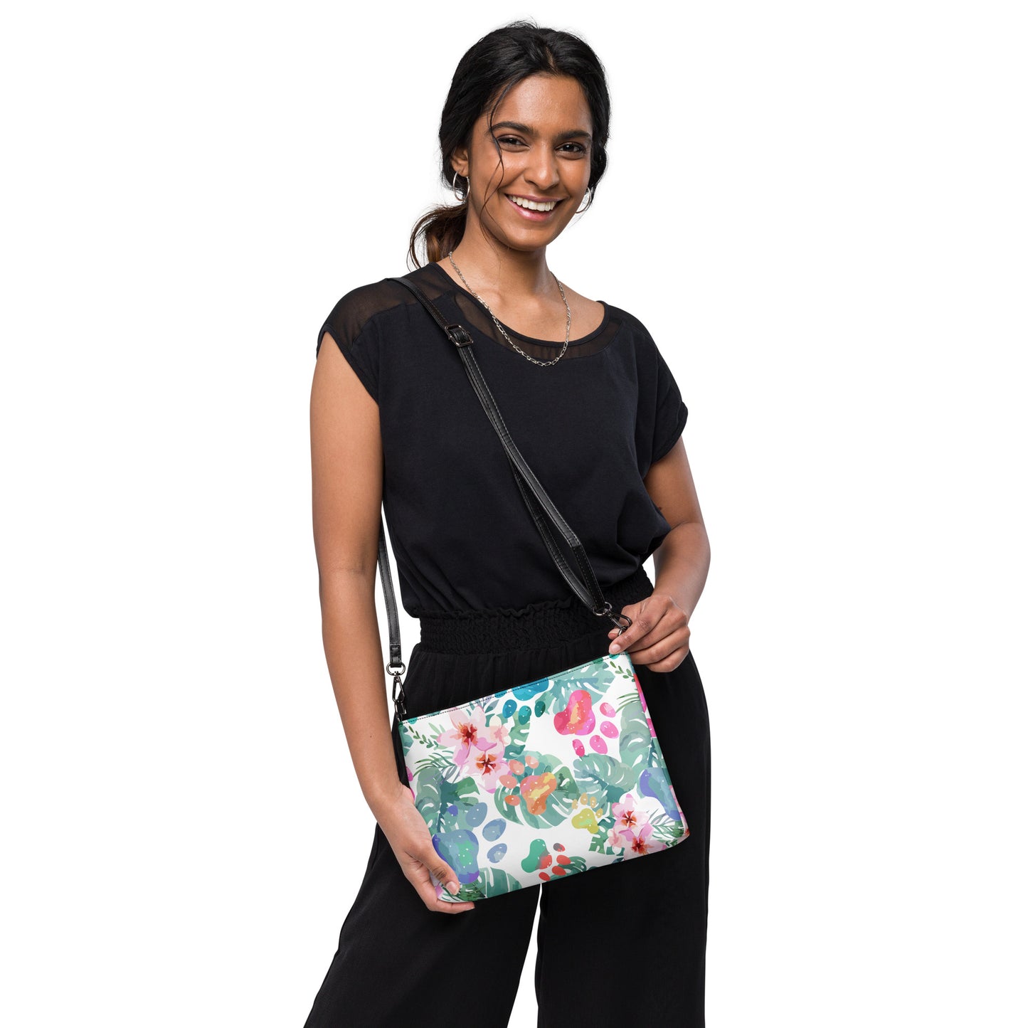 Woman holding a floral-patterned handbag with a black strap against a white background