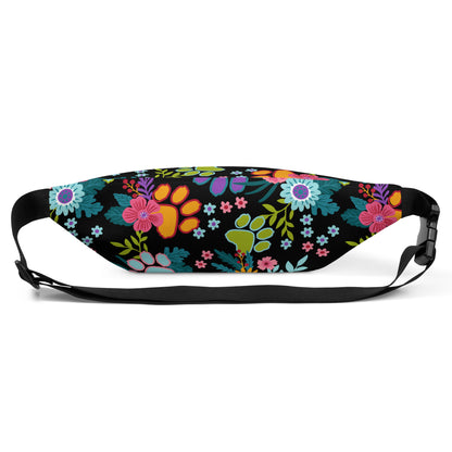 Floral Paw print pattern with a black background on a fanny pack with a black strap. Back view showing the clip.