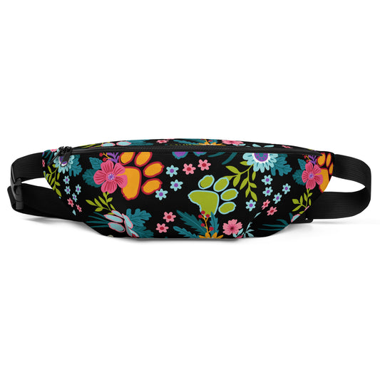 Floral Paw print pattern with a black background on a fanny pack with a black strap. Front view.