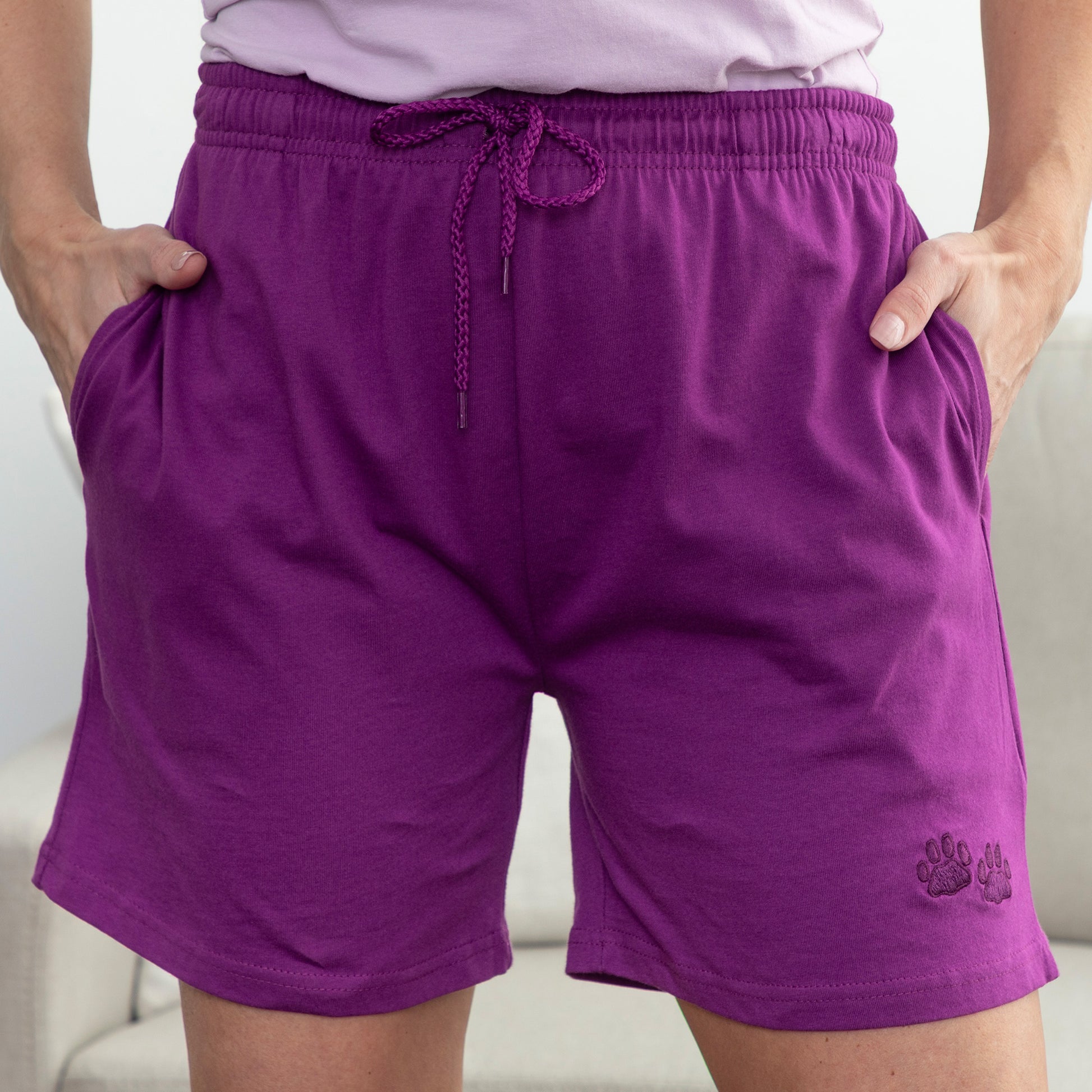 Purple shorts with a small embroidered purple paw print logo on a neutral background
