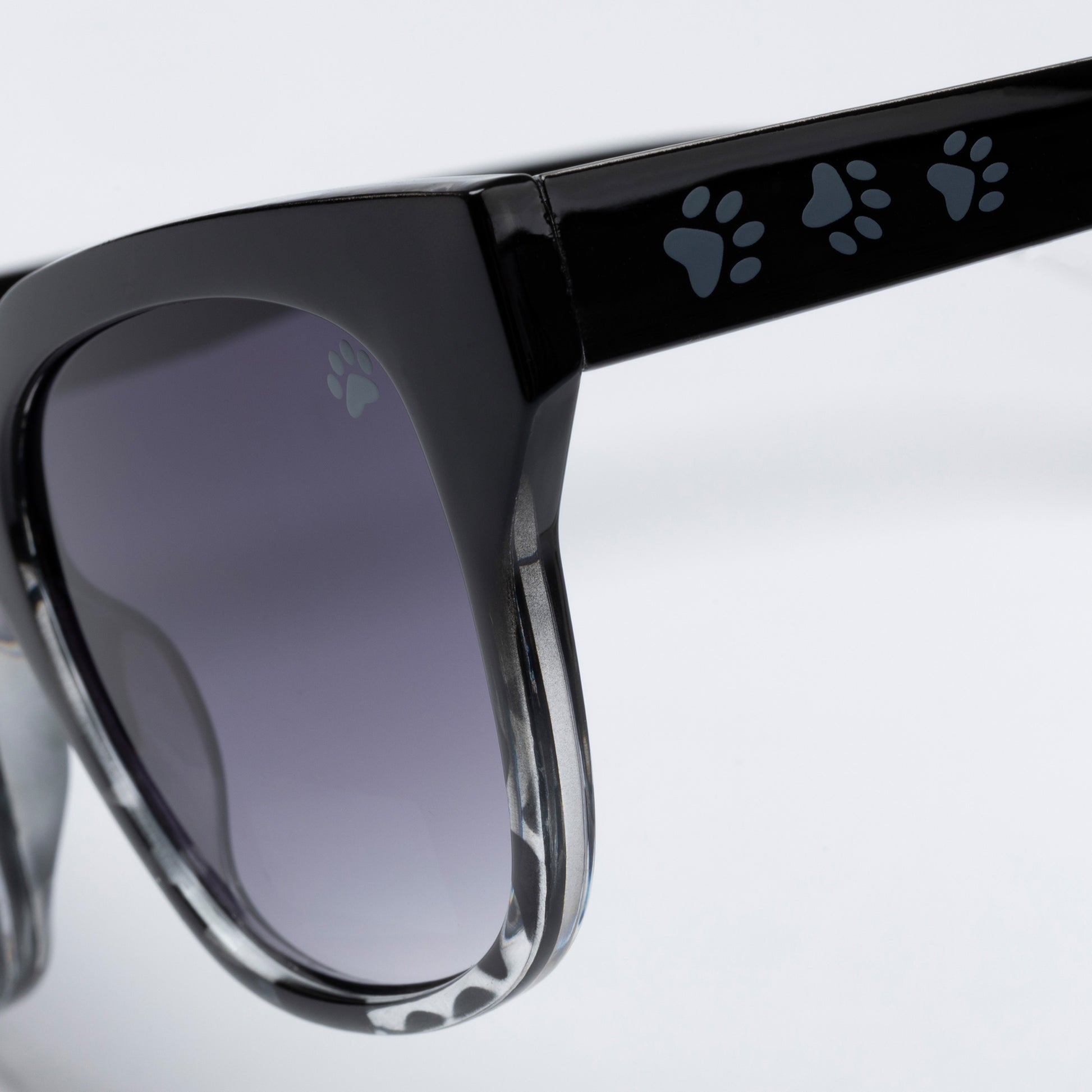 Black sunglasses with paw print design on arms against a light gray background