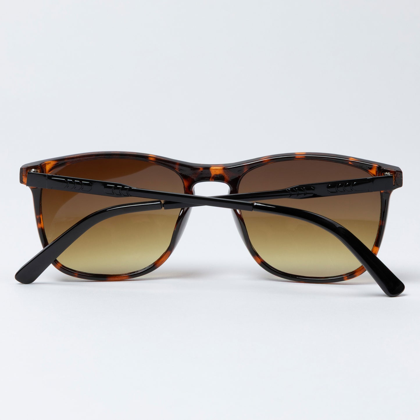 Sunglasses with tortoiseshell frame and brown lenses on a white background