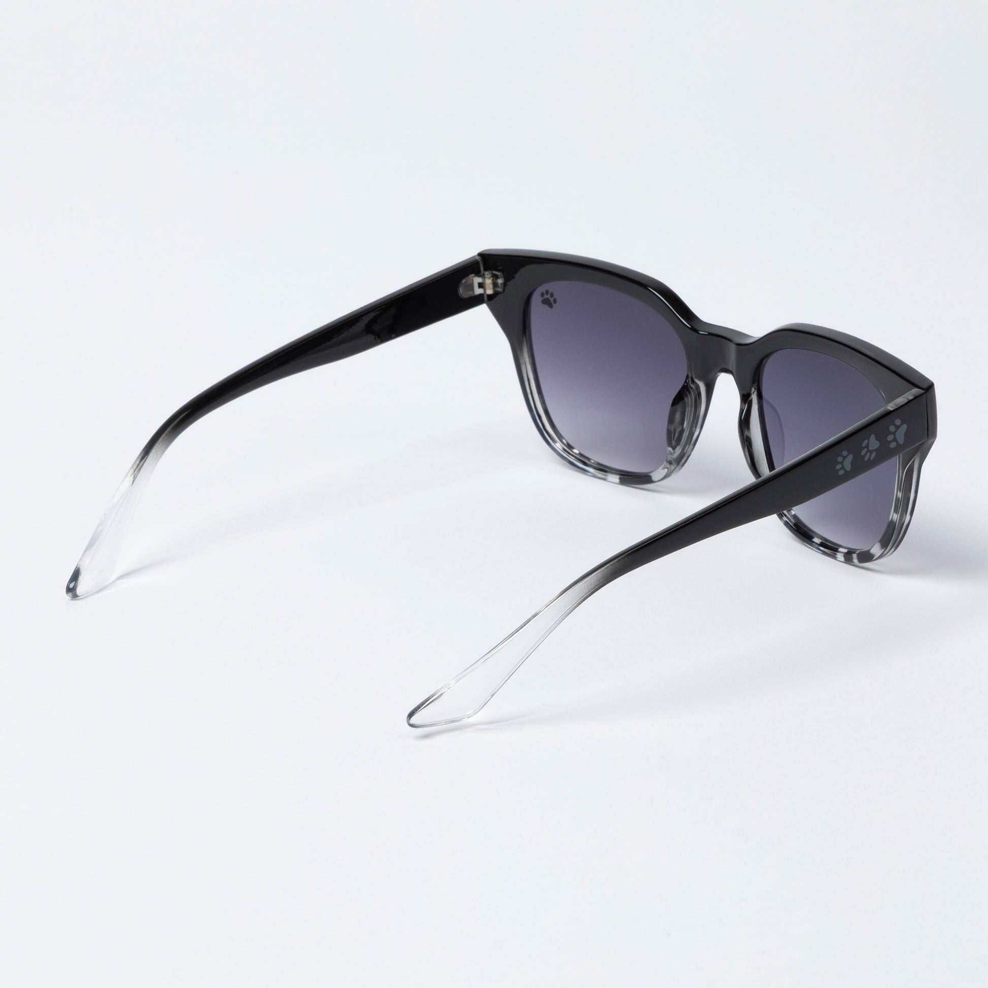 Black sunglasses with gradient lenses on a light gray background