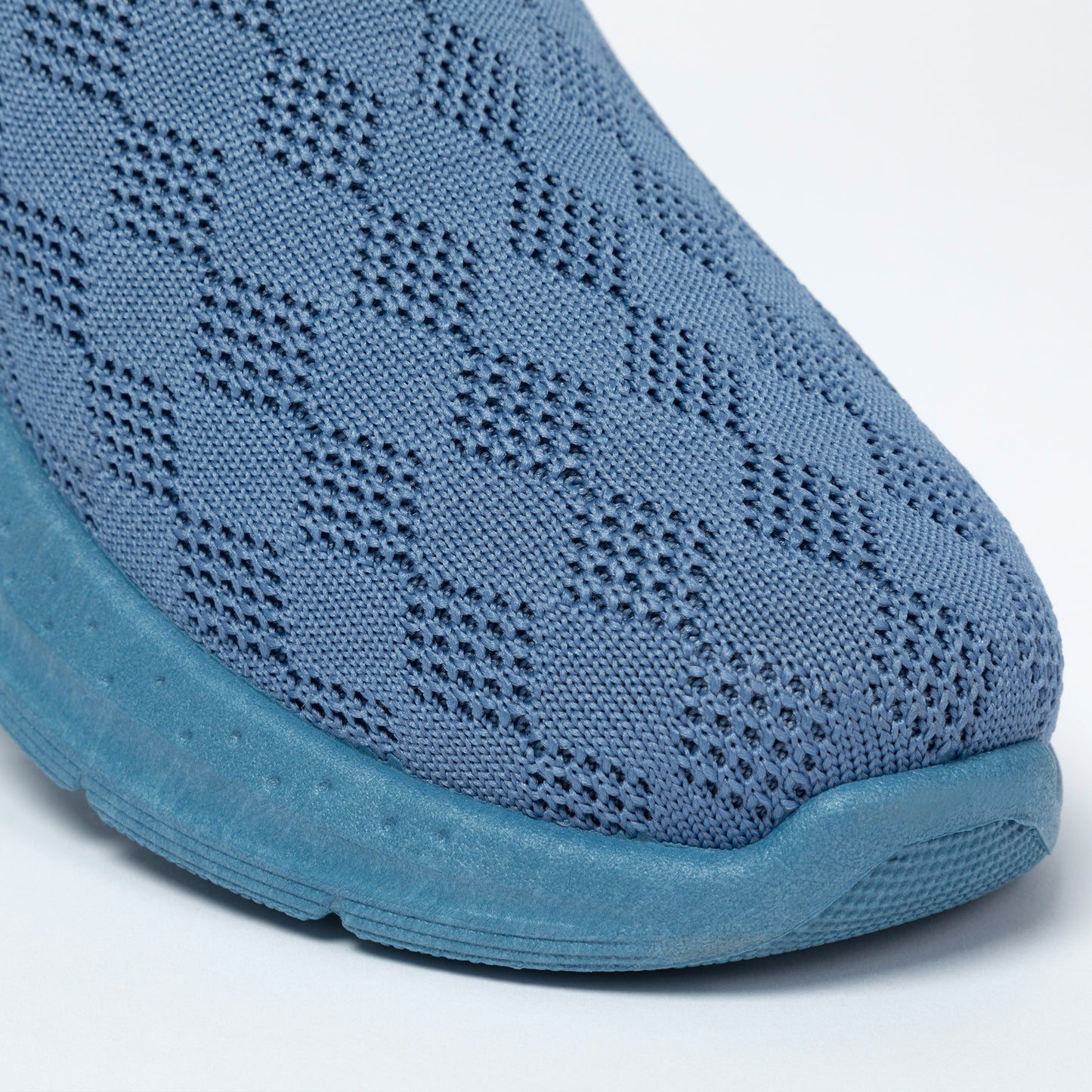 Blue slip-on shoe with knitted upper on a white background