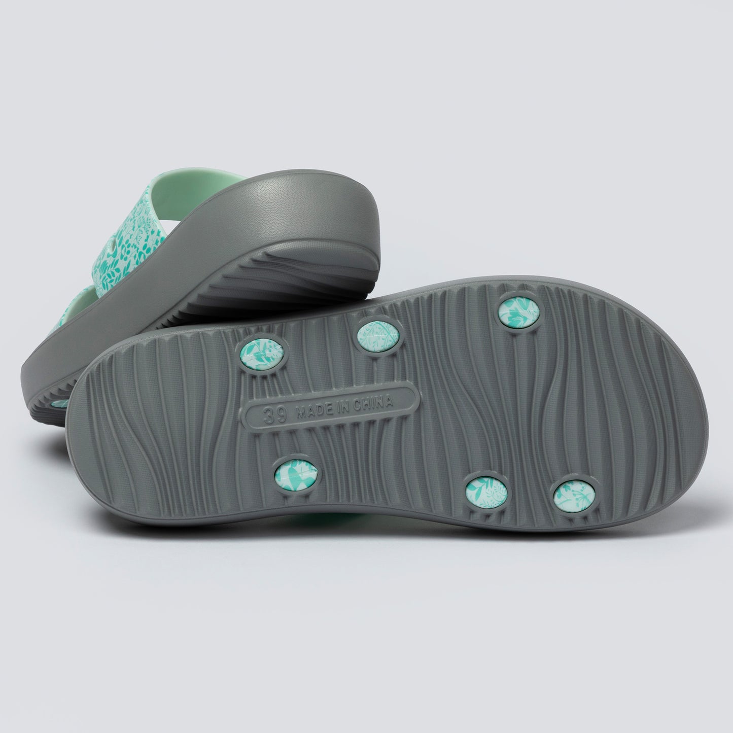 Pair of gray sandals with green accents on a light gray background
