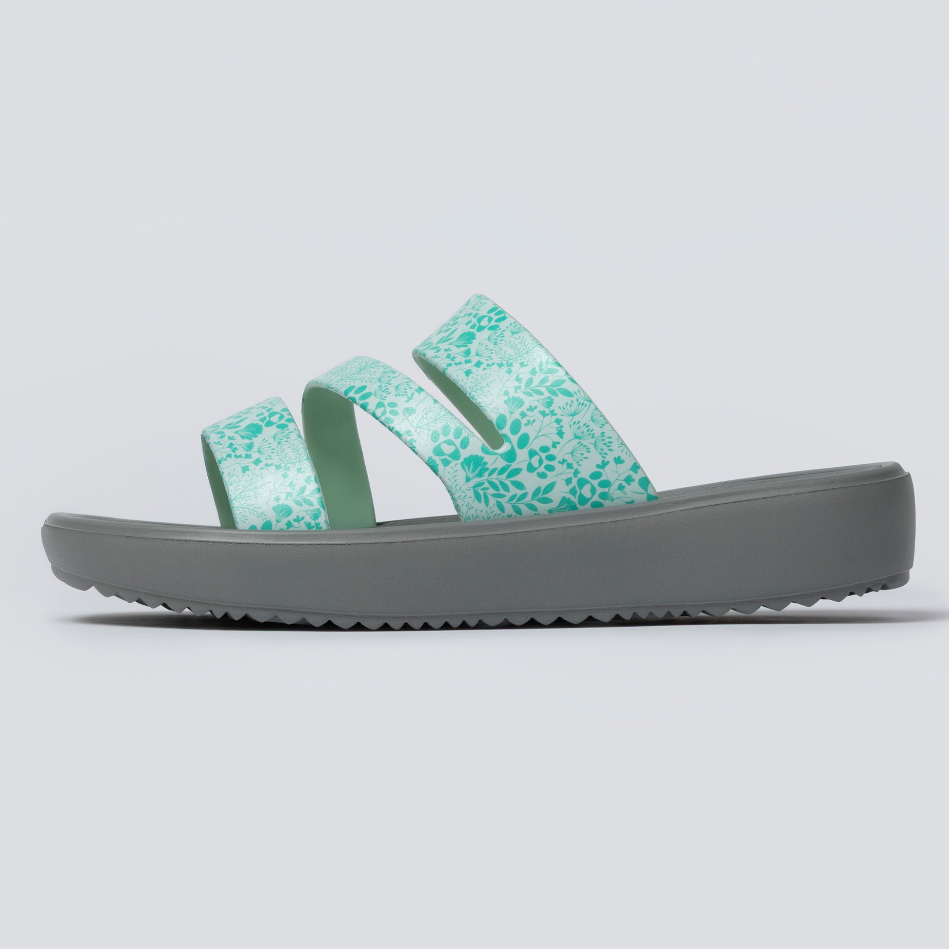 Green slide sandal with gray sole on a light gray background