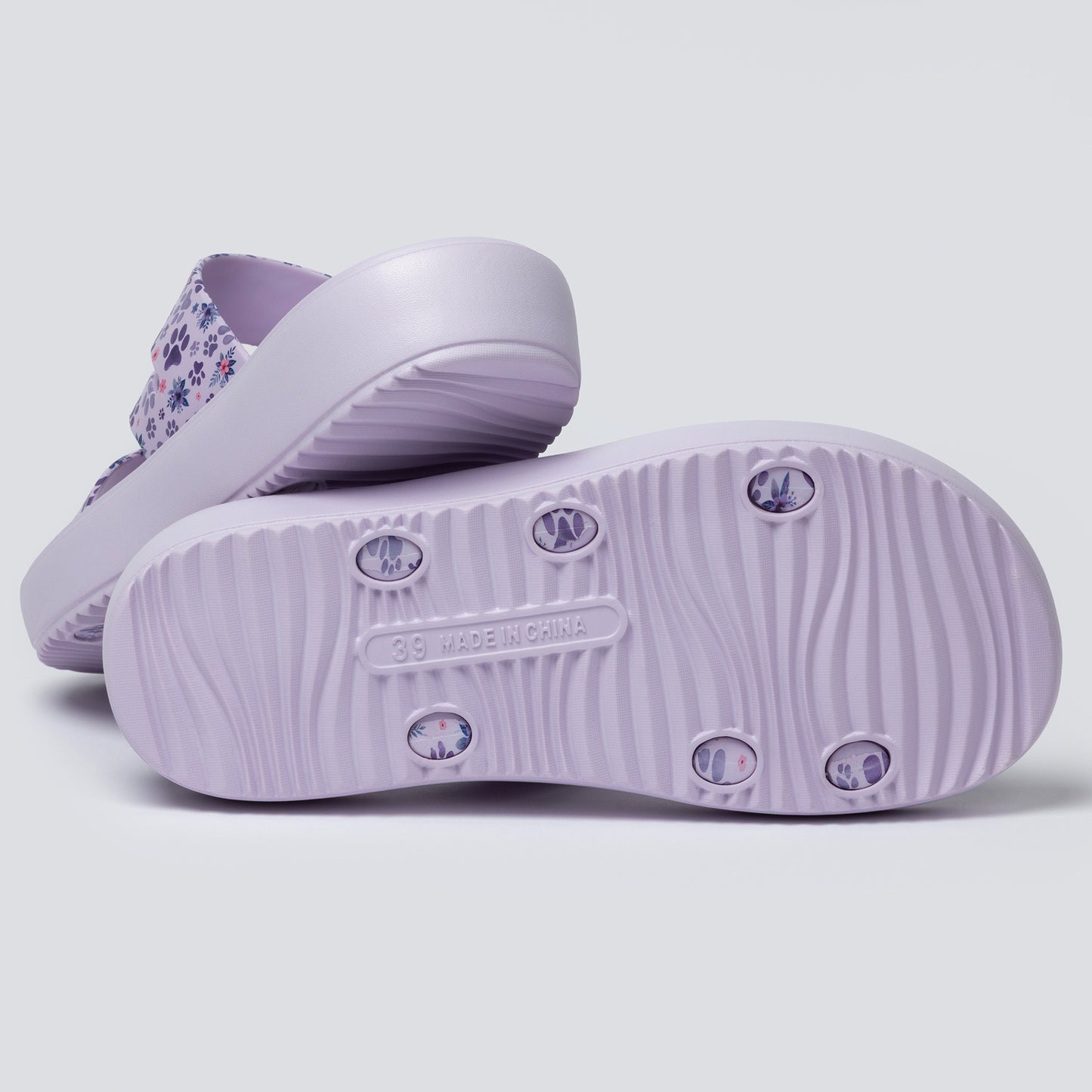 Purple sandals with floral pattern on a light gray background