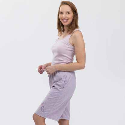 Woman wearing a light purple tank top and matching shorts on a white background.