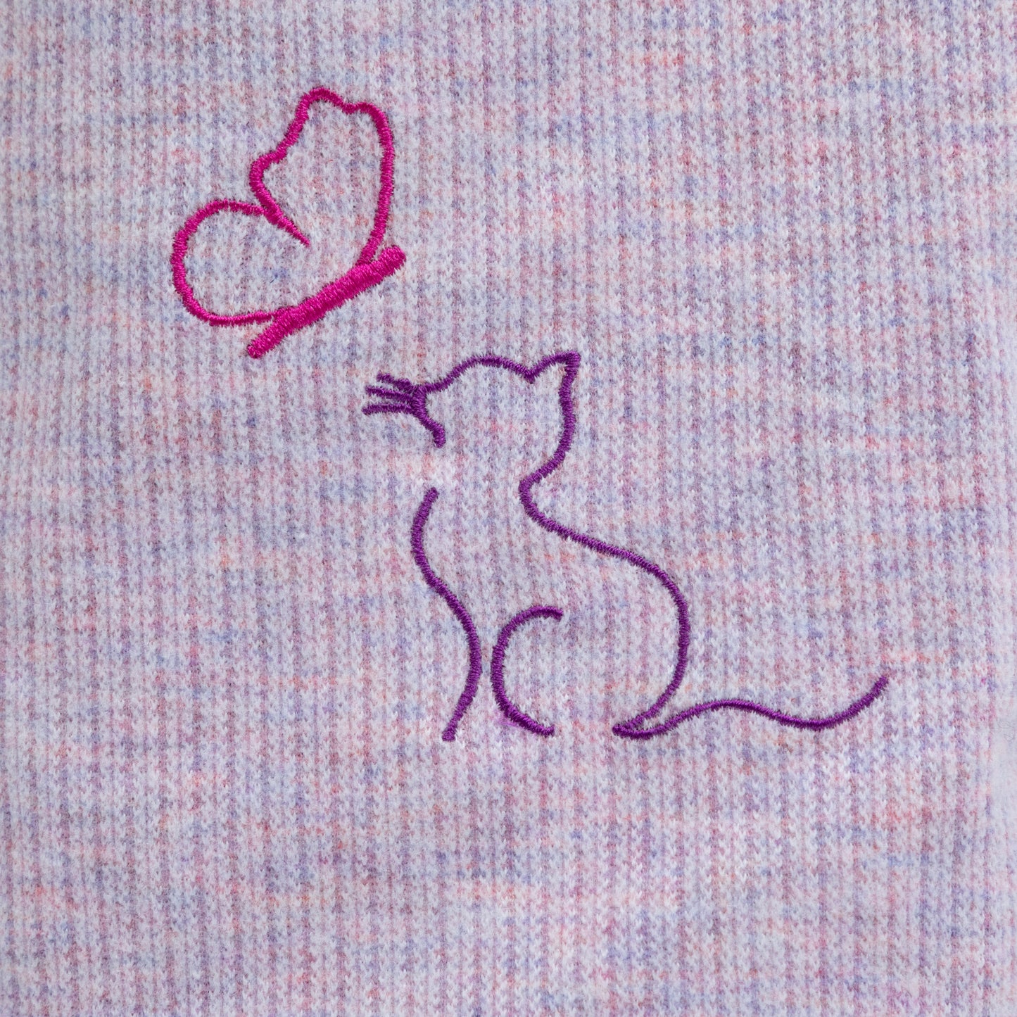 Embroidered design of a cat and a butterfly on melange purple fabric.