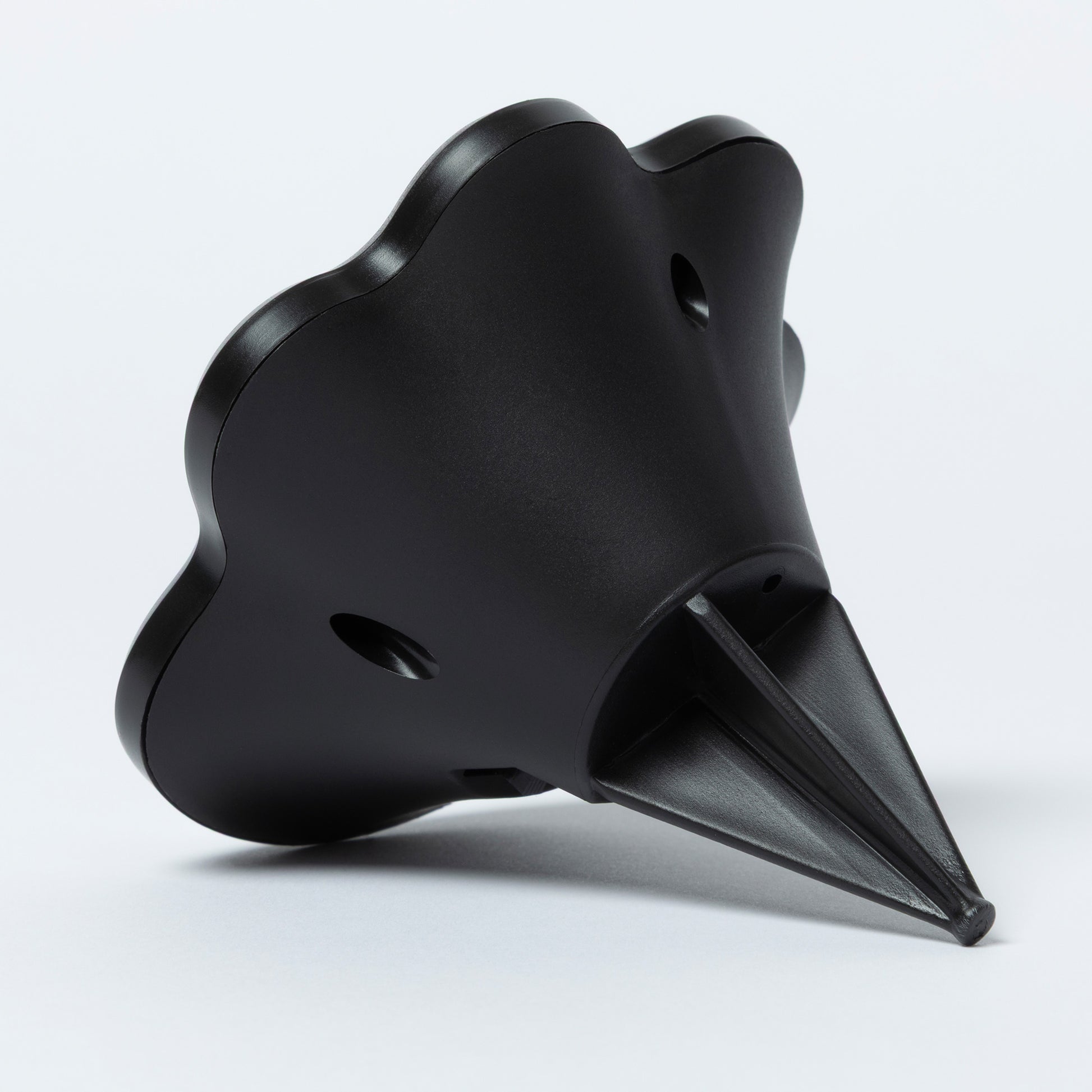 Black, cone-shaped object on a light gray background