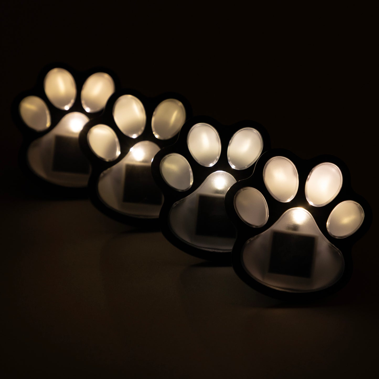 Set of paw-shaped lights on a black background