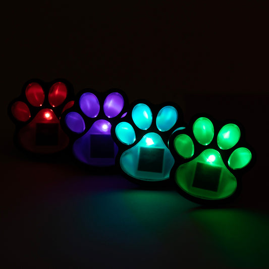 Set of glowing paw-shaped lights in red, purple, blue, and green on a dark background.