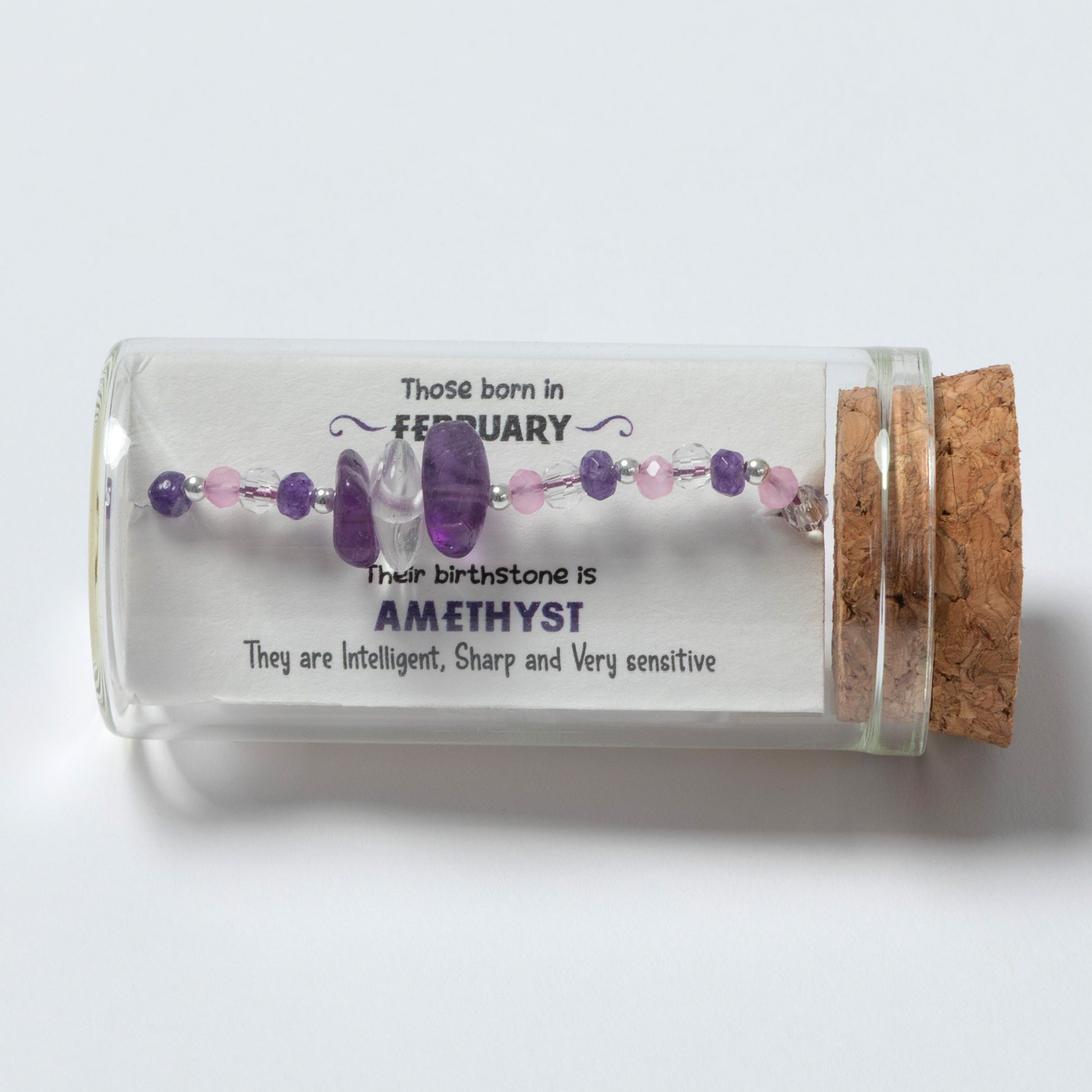 Glass bottle with amethyst beads and descriptive text on a white background