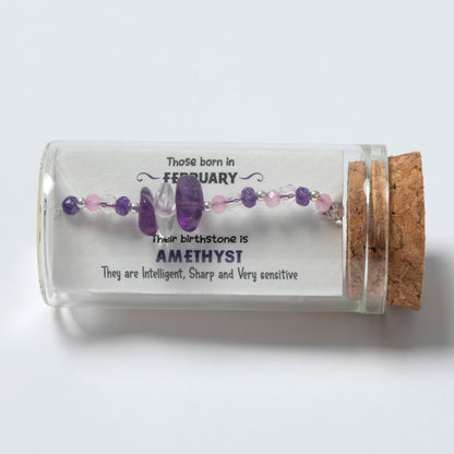 Glass bottle with amethyst beads and descriptive text on a white background