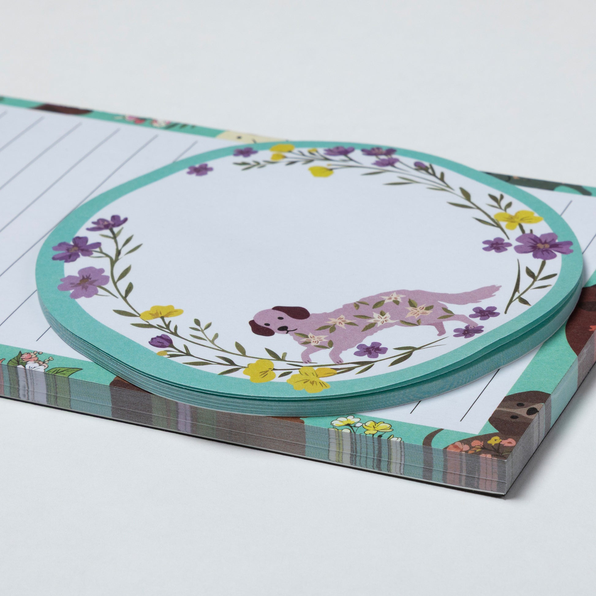 Stack of paper with floral and dog illustration on a white background