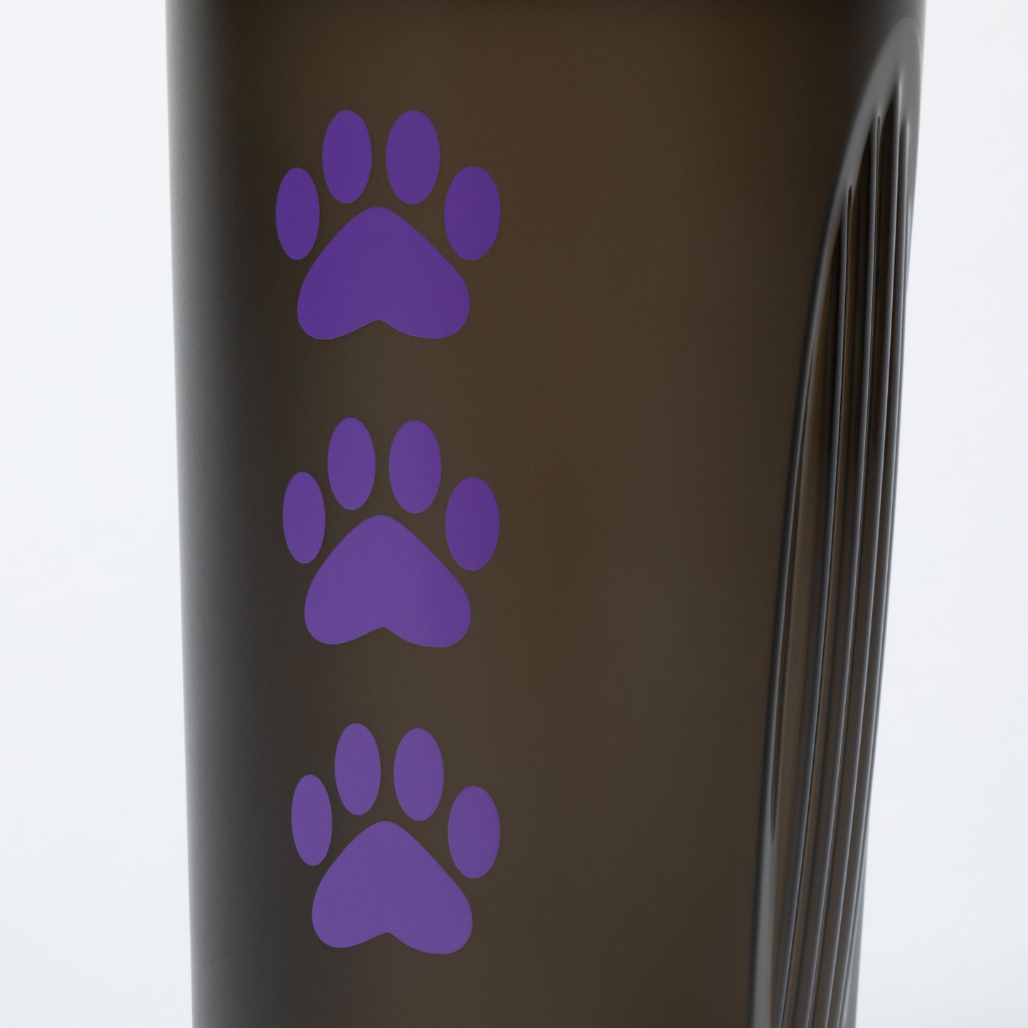 Black tumbler with purple paw prints on a white background