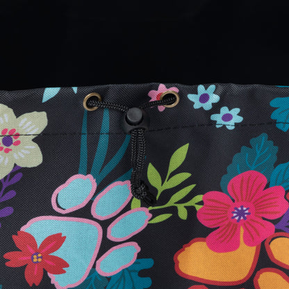 Close-up of a black drawstring bag featuring a colorful floral and paw print pattern in pink, blue, green, and orange.