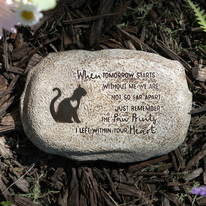 Decorative stone with engraved text and cat silhouette on a natural background