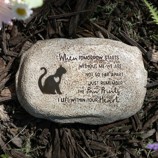 Decorative stone with engraved text and cat silhouette on a natural background
