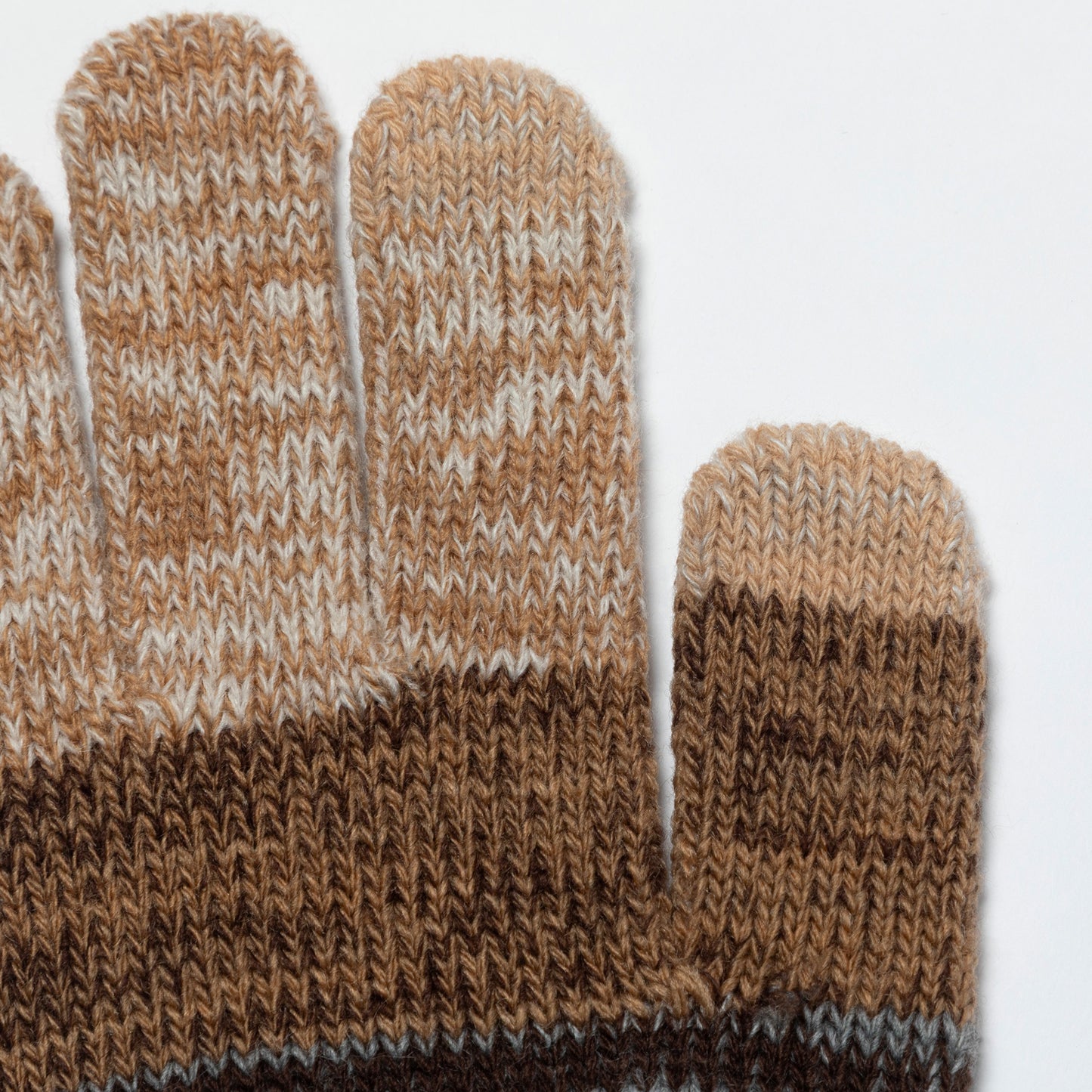 Close-up of a knit glove showing the fingers and back of the hand in a marled brown, tan, cream, and dark brown colorway, with a ribbed cuff.