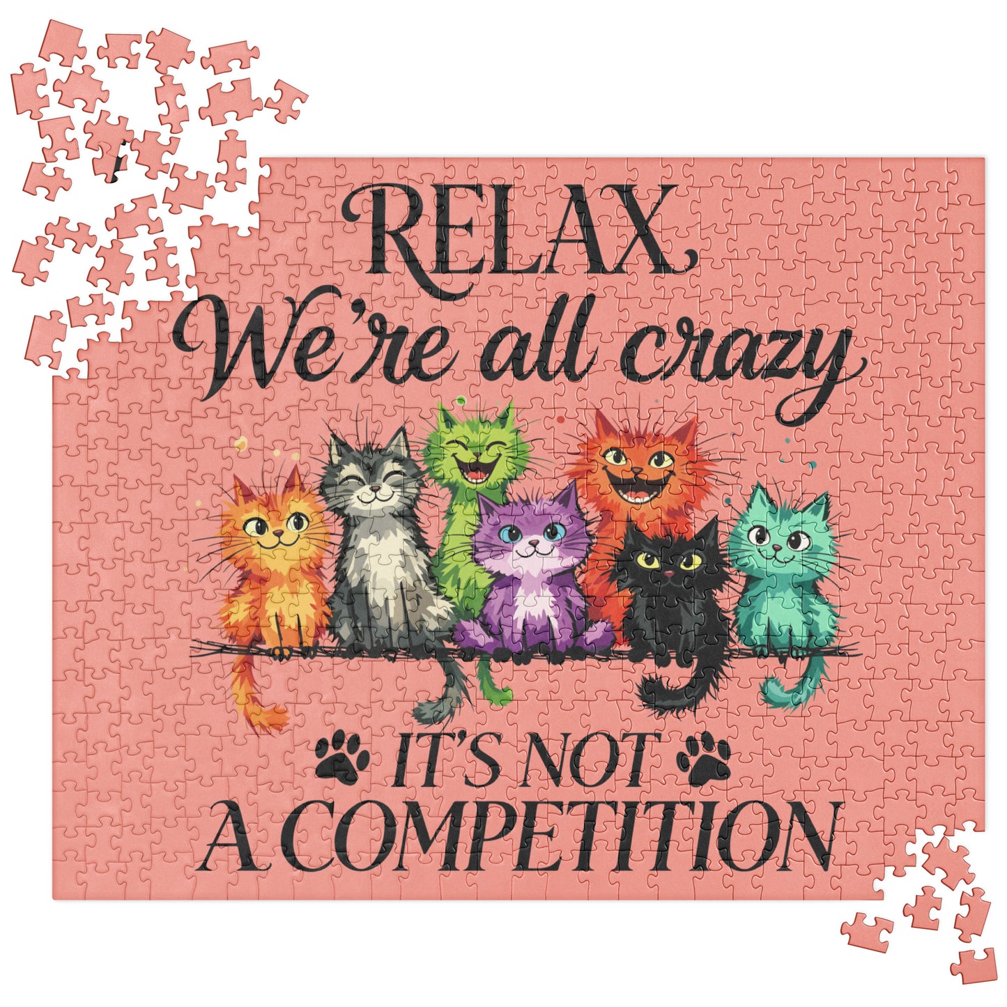 A completed jigsaw puzzle featuring a pink background with the text 'RELAX We're all crazy' and 'IT'S NOT A COMPETITION' in black script. Colorful cartoon cats sit on a branch across the center, and a few loose puzzle pieces are scattered around the corners.