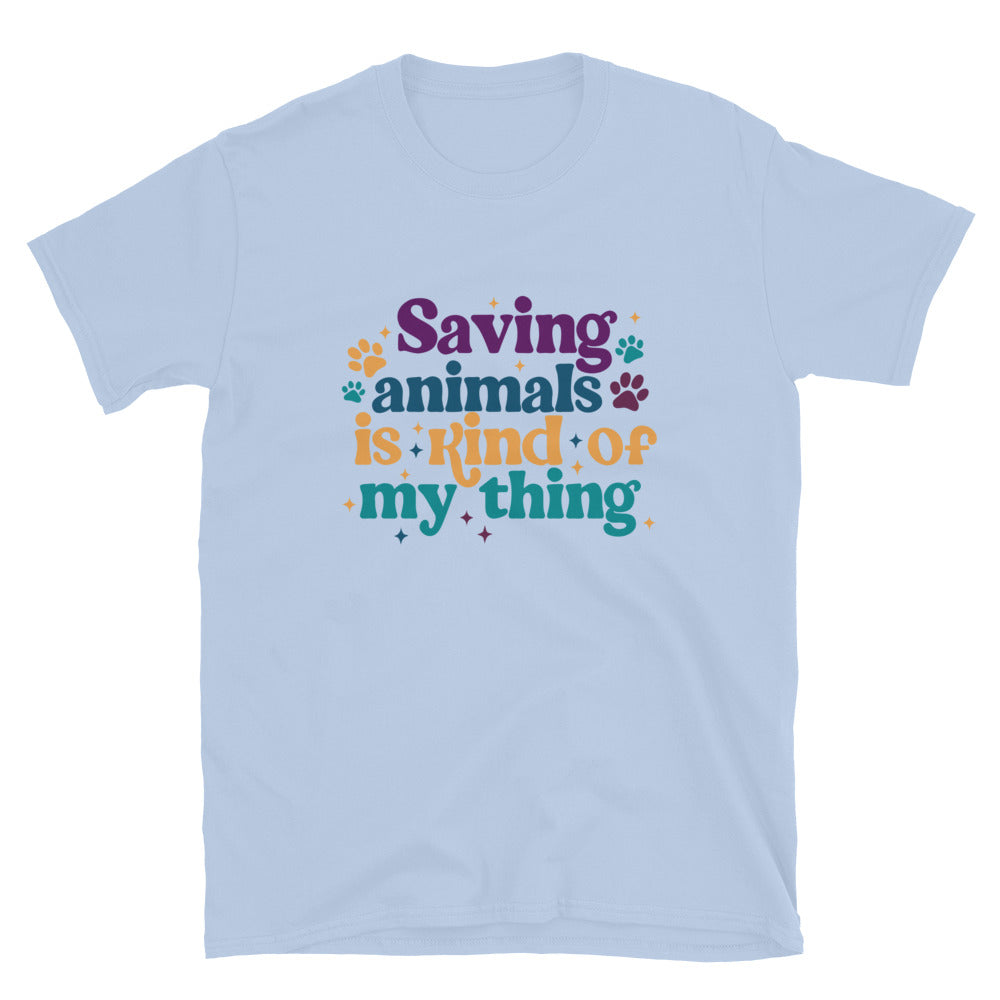 light blue shirt that reads Saving Animals is kind of my Thing with several paw print and sparkle images in a purple, yellow and blue font.