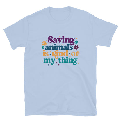 light blue shirt that reads Saving Animals is kind of my Thing with several paw print and sparkle images in a purple, yellow and blue font.