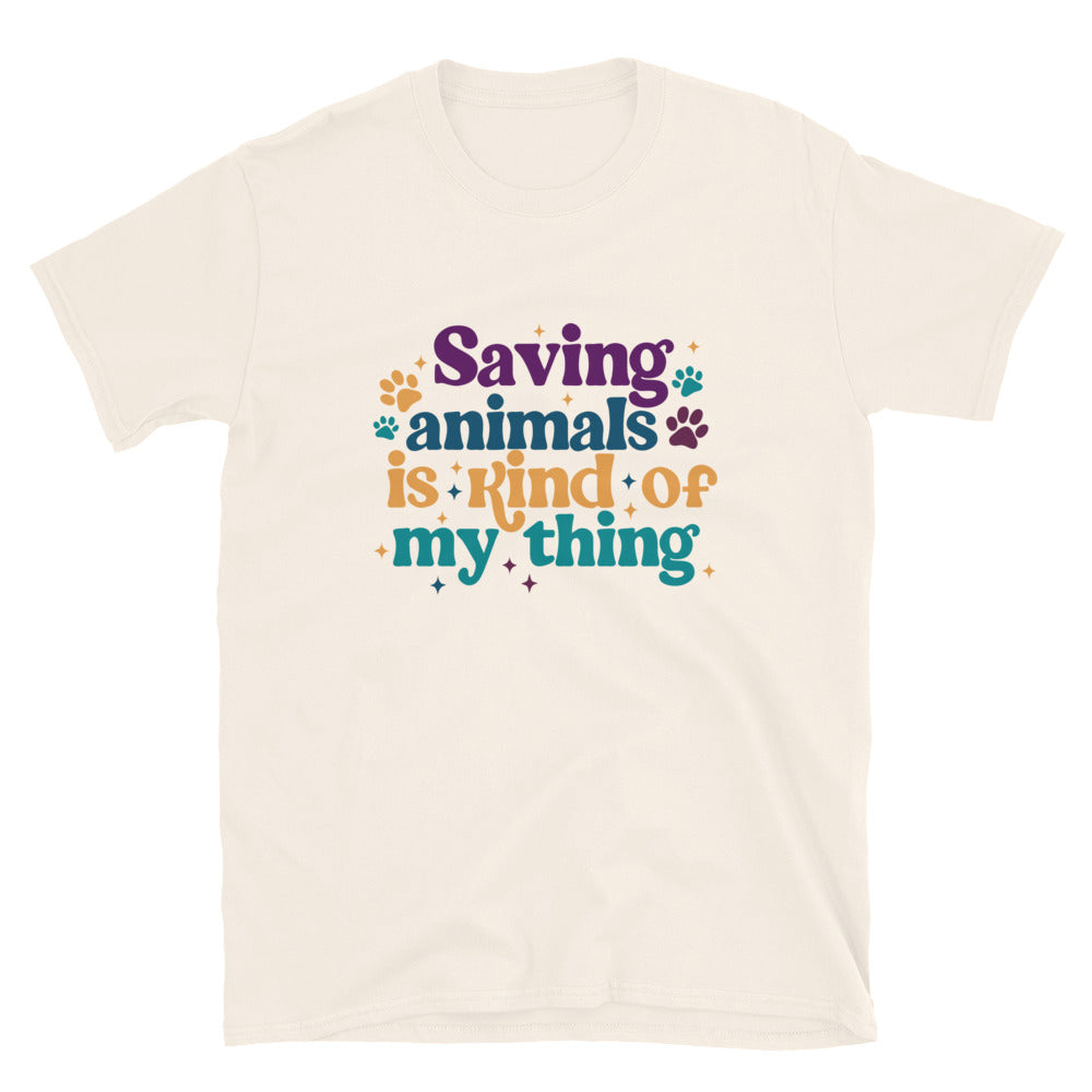 tan shirt that reads Saving Animals is kind of my Thing with several paw print and sparkle images in a purple, yellow and blue font.