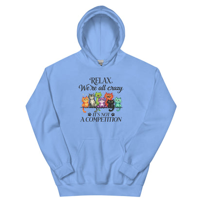 A light blue pullover hoodie with a graphic on the chest featuring a group of colorful cartoon cats and the text 'RELAX. We're all crazy. it's not a competition.
