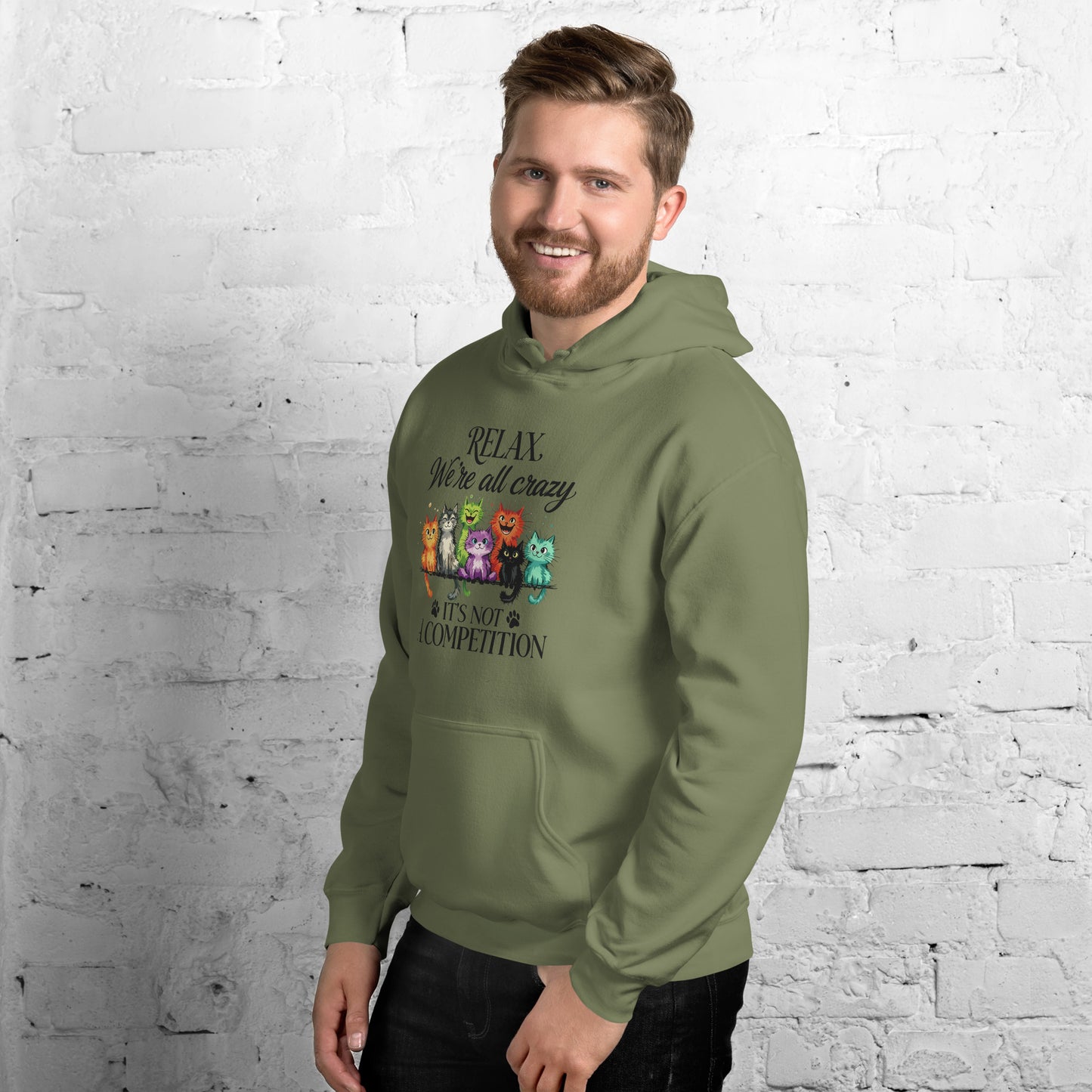 Man wearing a green hoodie standing against a white brick wall