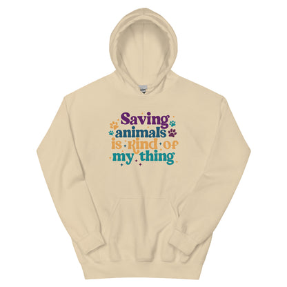 Tan Hooded Sweatshirt that reads Saving Animals is kind of my Thing with several paw print and sparkle images in a purple, yellow and blue font.