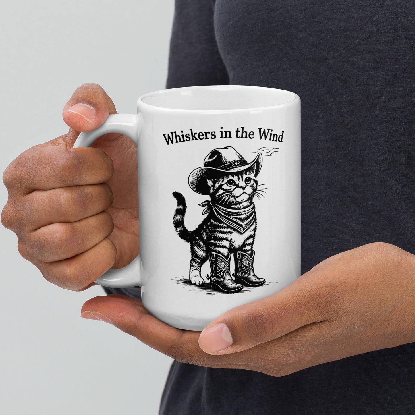Person holding a large white mug with a cat illustration and text 'Whiskers in the Wind' on a plain background