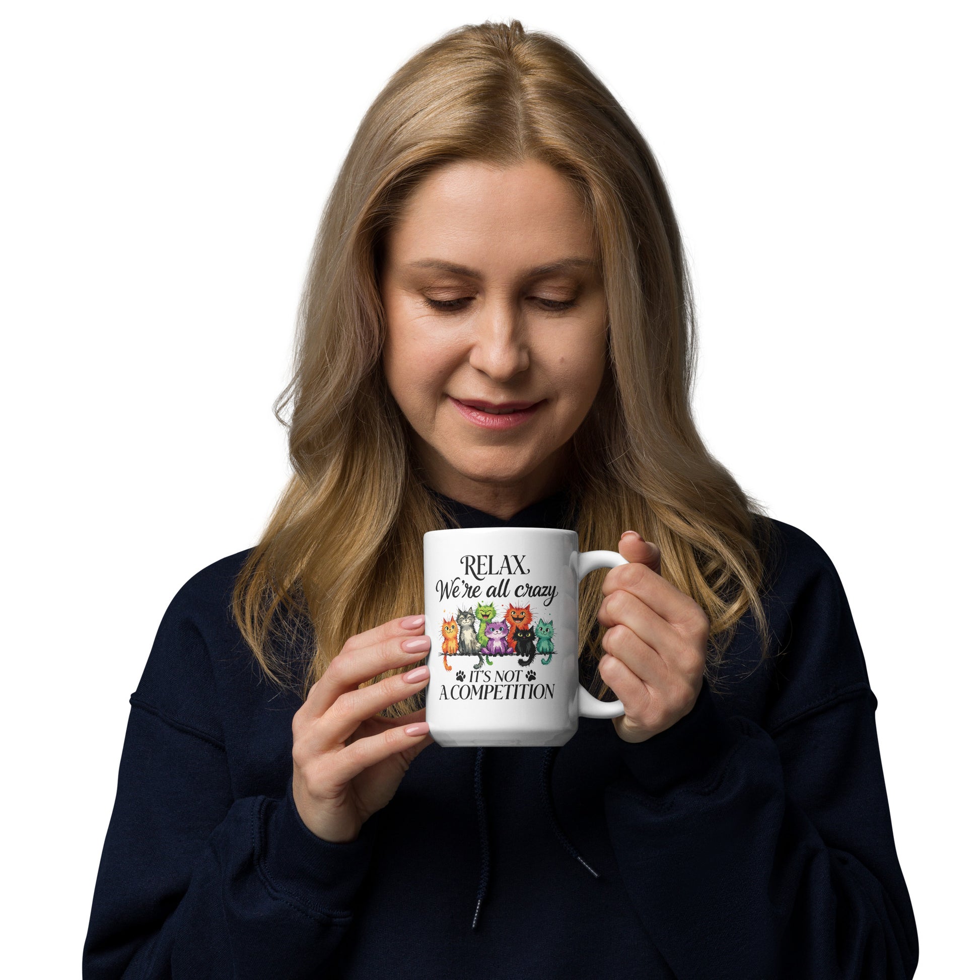 Woman holding a white mug with a cat design  that reads 'Relax, We're All Crazy. It's Not a competition" on a white background
